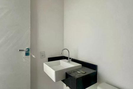 Apartamento à venda com 25m², 1 quarto e sem vagaBanheiro com pia e torneira em um ambiente branco e minimalista.