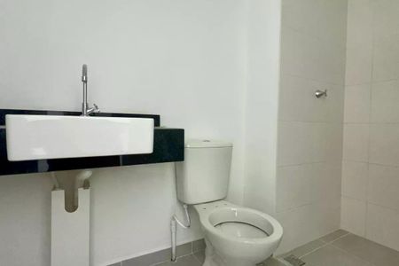 Apartamento à venda com 25m², 1 quarto e sem vagaBanheiro com pia e vaso sanitário brancos, paredes brancas e chão de porcelanato.