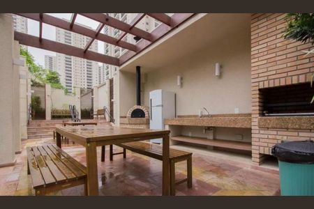 Apartamento à venda com 83m², 2 quartos e 2 vagas Apartamento à venda com 83m², 2 quartos e 2 vagasVaranda com mesa e banco, pizzaria e geladeira, com vista para edifícios altos.