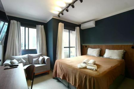 Quarto com cama de casal, sofá, mesa e cadeira, com vista para a cidade. de apartamento à venda com 1 quarto, 26m² em Moema, São Paulo