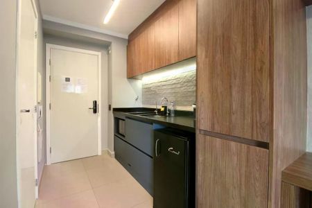 Cozinha com móveis de madeira e piso de porcelanato, com geladeira e fogão. de apartamento à venda com 1 quarto, 26m² em Moema, São Paulo