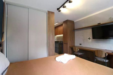 Apartamento à venda com 26m², 1 quarto e sem vagaQuarto com cama, armários e TV, com cozinha e banheiro no fundo.
