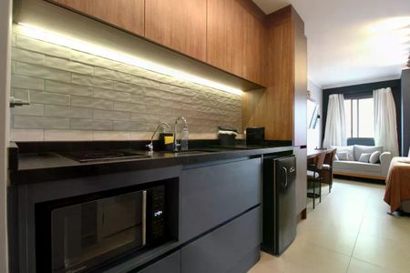 Cozinha moderna com móveis em madeira e piso de porcelanato, equipada com geladeira e fogão. de apartamento à venda com 1 quarto, 26m² em Moema, São Paulo