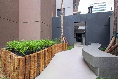 Studio à venda com 28m², 1 quarto e sem vagaEspaço externo de apartamento com jardim e bancos, ideal para relaxar e aproveitar o ar livre.