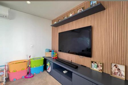 Apartamento à venda com 265m², 4 quartos e 3 vagasTelevisão de 55 polegadas em parede com painel de madeira e prateleiras de madeira acima e abaixo.