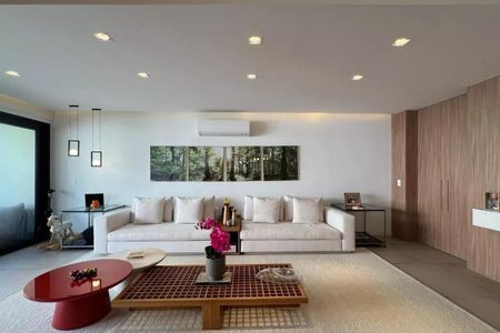 Apartamento à venda com 265m², 4 quartos e 3 vagasSala com sofá branco, mesas de madeira e móveis de design, iluminação adequada e decoração minimalista.