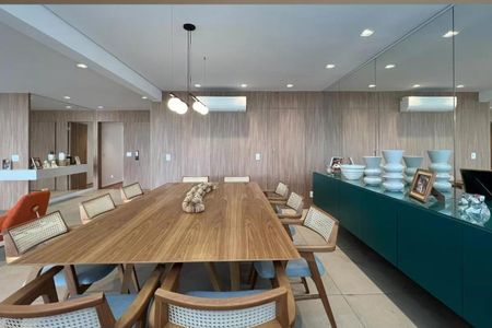 Apartamento à venda com 265m², 4 quartos e 3 vagasSala com mesa de madeira e cadeiras de madeira e tecido, com um aparador de madeira e um espelho grande na parede.
