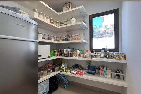 Apartamento à venda com 265m², 4 quartos e 3 vagasArmário de cozinha com prateleiras e geladeira, iluminado por uma janela.