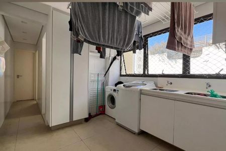 Apartamento à venda com 265m², 4 quartos e 3 vagasLavanderia com móveis brancos e janela grande, com roupas penduradas para secar.