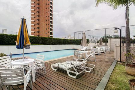 Apartamento à venda com 93m², 4 quartos e 2 vagasPiscina com deck e cadeiras de praia, vista para a cidade, com edifício de apartamentos ao fundo.