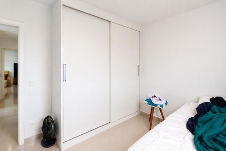 Apartamento à venda com 93m², 4 quartos e 2 vagasQuarto com móveis brancos e um ventilador no canto.