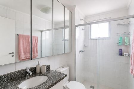 Apartamento à venda com 93m², 4 quartos e 2 vagasBanheiro com piso de porcelanato, vaso sanitário e chuveiro, com espelho e prateleira acima do vaso sanitário.