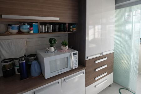 Apartamento à venda com 70m², 2 quartos e 1 vagaBanheiro com piso de porcelanato, micro-ondas e vasos de decoração.