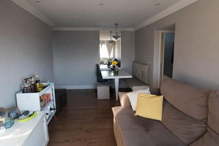 Apartamento à venda com 70m², 2 quartos e 1 vagaSala de estar com sofá, mesa e cadeiras, e uma pequena cozinha no fundo.