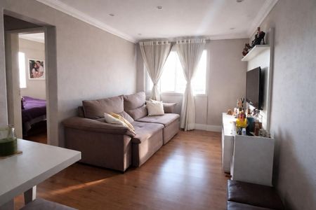 Apartamento à venda com 70m², 2 quartos e 1 vagaSala de estar com sofá e TV, com uma porta para o quarto e uma janela com cortinas brancas.