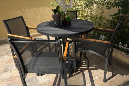 Apartamento à venda com 48m², 2 quartos e 1 vaga Apartamento à venda com 48m², 2 quartos e 1 vagaMesas e cadeiras de jardim em um pátio com plantas e um muro amarelo.