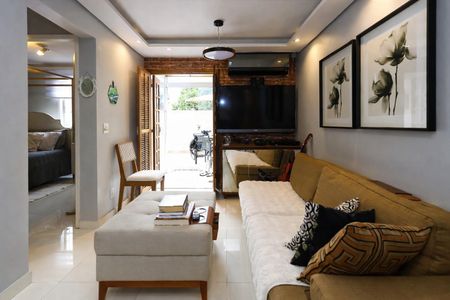 Sala de estar com sofá, TV e móveis de madeira, com vista para o jardim. de apartamento à venda com 2 quartos, 48m² em Morumbi, São Paulo