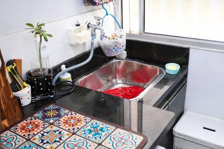 Apartamento à venda com 48m², 2 quartos e 1 vaga Apartamento à venda com 48m², 2 quartos e 1 vagaCozinha com pia e fogão, com móveis de madeira e azulejos coloridos.