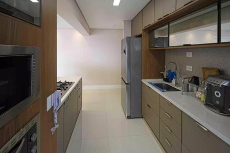 Apartamento à venda com 121m², 6 quartos e 2 vagasCozinha moderna com móveis de madeira e iluminação adequada.