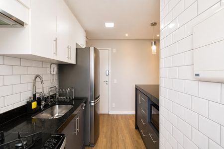 Apartamento à venda com 60m², 2 quartos e 1 vagaCozinha com móveis de cor preta e branco, com geladeira e fogão, e piso de madeira.