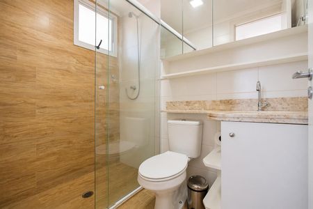 Apartamento à venda com 60m², 2 quartos e 1 vagaBanheiro com piso de porcelanato, vaso sanitário e chuveiro, e armários com espelho.