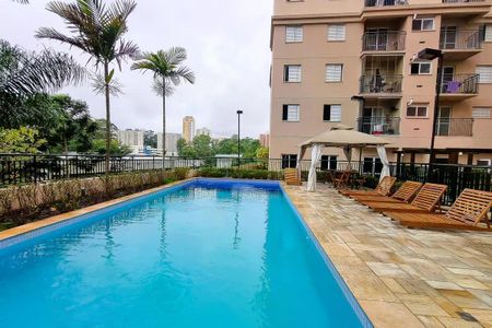 Apartamento à venda com 60m², 2 quartos e 1 vagaPiscina com vista para a cidade, cercada por palmeiras e com uma varanda ao lado.
