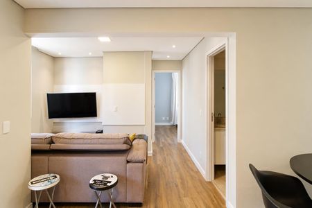 Sala de estar com sofá e TV montada na parede, com uma pequena mesa e duas cadeiras ao lado. de apartamento à venda com 2 quartos, 60m² em Jardim Parque Morumbi, São Paulo