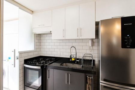 Apartamento à venda com 60m², 2 quartos e 1 vagaCozinha com geladeira, fogão e pia, com móveis brancos e azuis, e teto branco.