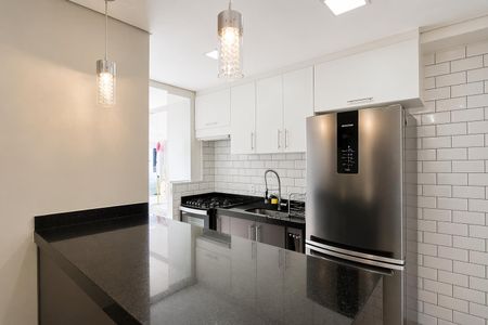 Apartamento à venda com 60m², 2 quartos e 1 vagaCozinha com piso de porcelanato, armários brancos, pia e fogão em aço inox, geladeira e iluminação moderna.