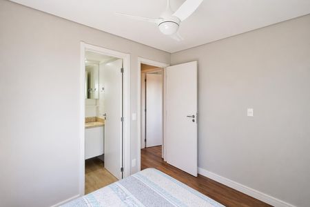Apartamento à venda com 60m², 2 quartos e 1 vagaQuarto com cama, piso de madeira e porta aberta para banheiro.