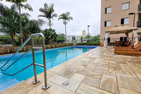 Apartamento à venda com 60m², 2 quartos e 1 vagaPiscina com escada e deck de pedra, cercada por palmeiras e árvores, com vista para a cidade.
