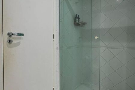 Banheiro com chuveiro e pia, com uma porta de vidro e um espelho no fundo. de kitnet/studio à venda com 1 quarto, 31m² em Pinheiros, São Paulo