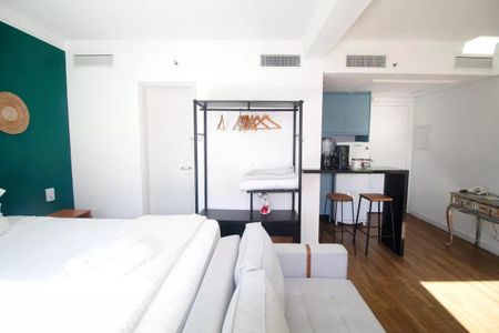 Quarto com cama de casal, sofá, mesa e cadeira, com vista para a cidade. de kitnet/studio à venda com 1 quarto, 31m² em Pinheiros, São Paulo
