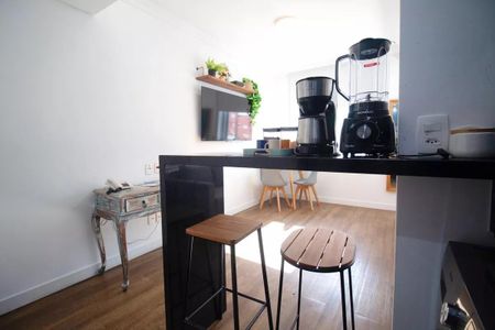 Casa com cozinha moderna e iluminada, com móveis de madeira e equipamentos de cozinha. de kitnet/studio à venda com 1 quarto, 31m² em Pinheiros, São Paulo