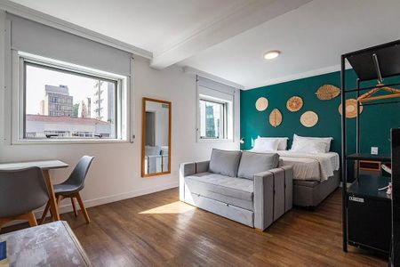 Quarto com cama de casal, sofá, mesa e cadeira, com vista para a cidade. de kitnet/studio à venda com 1 quarto, 31m² em Pinheiros, São Paulo