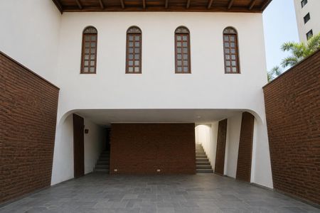 Casa à venda com 117m², 3 quartos e 3 vagas Casa à venda com 117m², 3 quartos e 3 vagasPátio com piso de pedra e janelas arqueadas, com uma escada ao fundo.