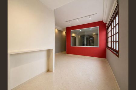 Sala com paredes brancas e vermelhas, piso de porcelanato e janela com persianas de madeira. de casa à venda com 3 quartos, 117m² em Vila Gomes Cardim, São Paulo