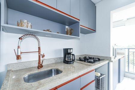 Apartamento à venda com 135m², 3 quartos e 3 vagas Apartamento à venda com 135m², 3 quartos e 3 vagasCozinha com móveis azuis e prateados, com uma vista para a varanda.