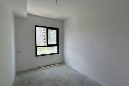 Apartamento à venda com 63m², 2 quartos e 1 vagaParede branca com janela preta e vista para edifício de apartamentos.