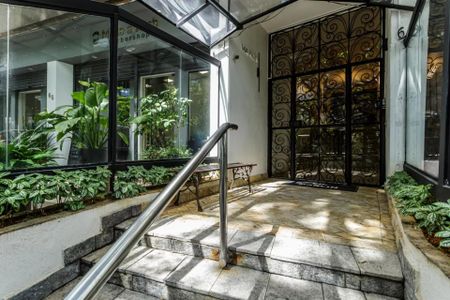 Apartamento à venda com 105m², 3 quartos e 1 vagaEntrada de um prédio com escada e jardim, com uma loja de conveniência ao lado.