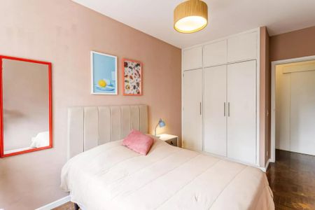 Apartamento à venda com 105m², 3 quartos e 1 vagaQuarto com cama simples, com um espelho e duas pinturas na parede, com uma porta de entrada e uma porta de saída.