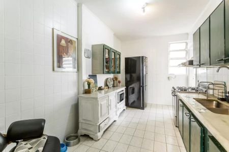 Apartamento à venda com 105m², 3 quartos e 1 vagaCozinha com geladeira, fogão e móveis brancos e verdes, com uma pintura na parede.
