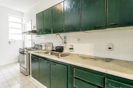 Apartamento à venda com 105m², 3 quartos e 1 vagaCozinha com móveis verdes e piso de azulejos brancos, com uma pia e fogão.