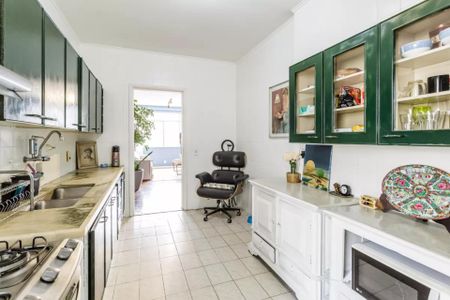 Apartamento à venda com 105m², 3 quartos e 1 vagaCozinha com móveis brancos e azuis, iluminada por luz natural e com um ambiente aconchegante.