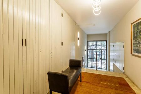 Apartamento à venda com 105m², 3 quartos e 1 vagaCorredor com porta de vidro e bancada de madeira, iluminado por lâmpadas de design moderno.