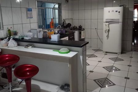 Casa à venda com 300m², 3 quartos e 5 vagasCozinha com geladeira, fogão e pia, com móveis brancos e azuis, e chão de porcelanato.