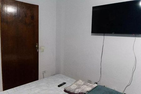 Casa à venda com 300m², 3 quartos e 5 vagasQuarto com TV e porta de madeira, com um tapete de carpete e uma televisão montada na parede.