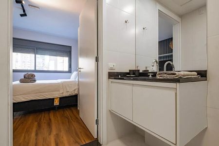 Banheiro com piso de porcelanato e pia de granito, iluminado por luzes de LED. de kitnet/studio à venda com 1 quarto, 26m² em Pinheiros, São Paulo