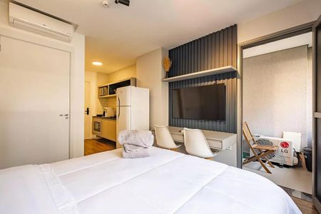 Quarto com cama de casal, TV e geladeira, com uma vista para a cidade. de kitnet/studio à venda com 1 quarto, 26m² em Pinheiros, São Paulo