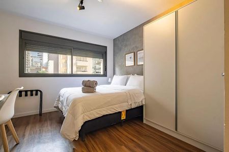 Quarto com cama de casal, armário e janela grande, com vista para a cidade. de kitnet/studio à venda com 1 quarto, 26m² em Pinheiros, São Paulo